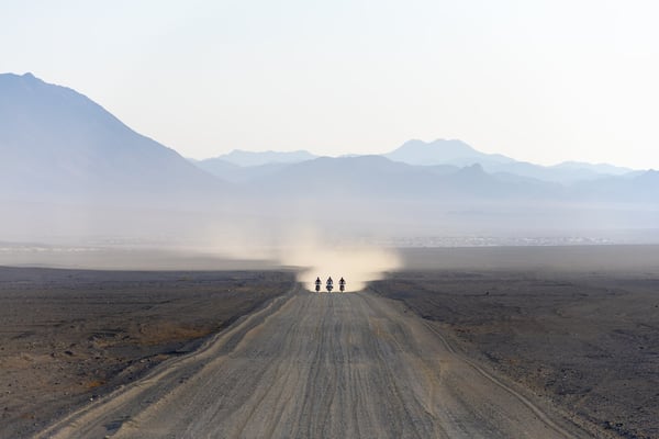 3 2020 Honda Africa Twins riding through the desert leaving dust in their wake.