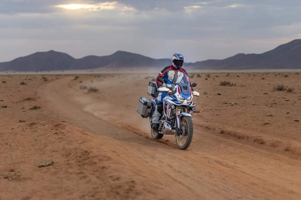 Rider kicking up dust as he rides the 2020 Honda Africa Twin in the desert.