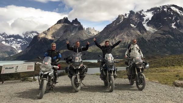 group of customers in patagonia celebrating with towering mountains in the background.