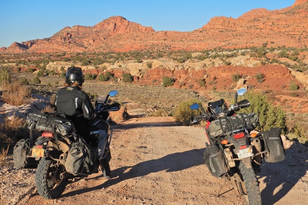 Tyler out in Utah's backcountry looking out into the mountainous distance on his adventure motorcycle with Giant Loop's RTW soft luggage equipped
