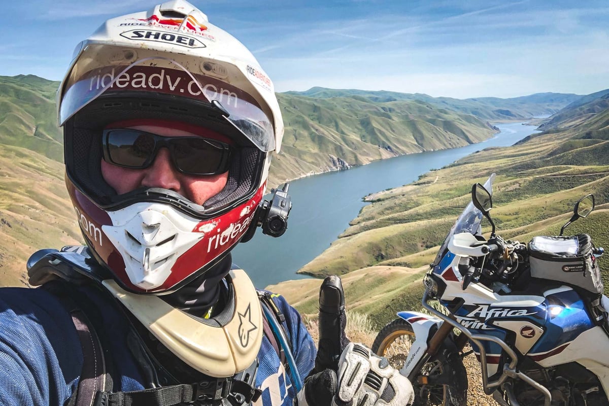 Eric with his motorcycle on a cool roadside stop overlooking a canyon in Oregon