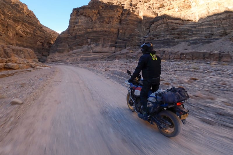 Adv rider riding through a canyon while visually taking it all in.