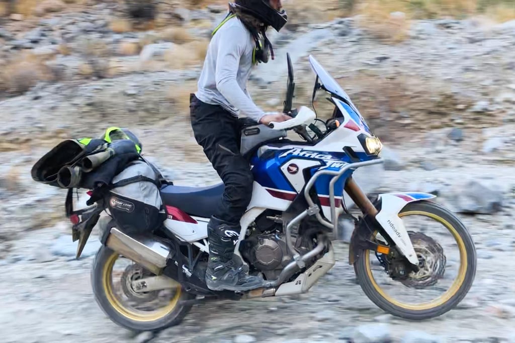 Tyler riding an Africa Twin in California on a dirt trail with the Tech 7's.