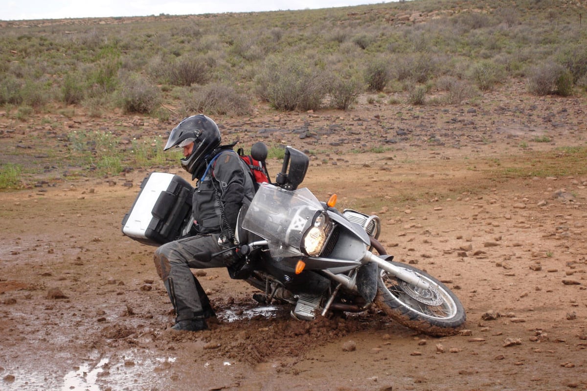 Rider picking up a big adventure bike after a spill offroad. 