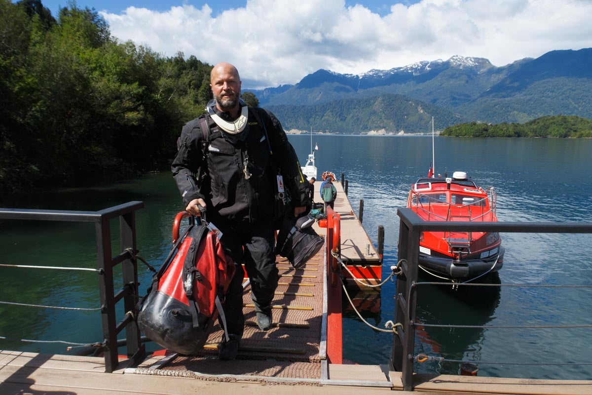 Eric carrying customers adventure motorcycle gear from a transfer boat in Patagonia