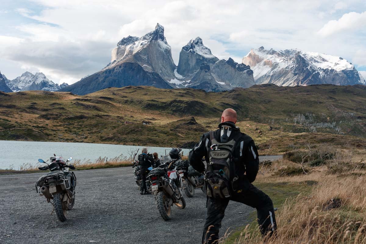 Eric with full adventure motorcycle gear on while looking up at Los Cuernos in Patagonia.