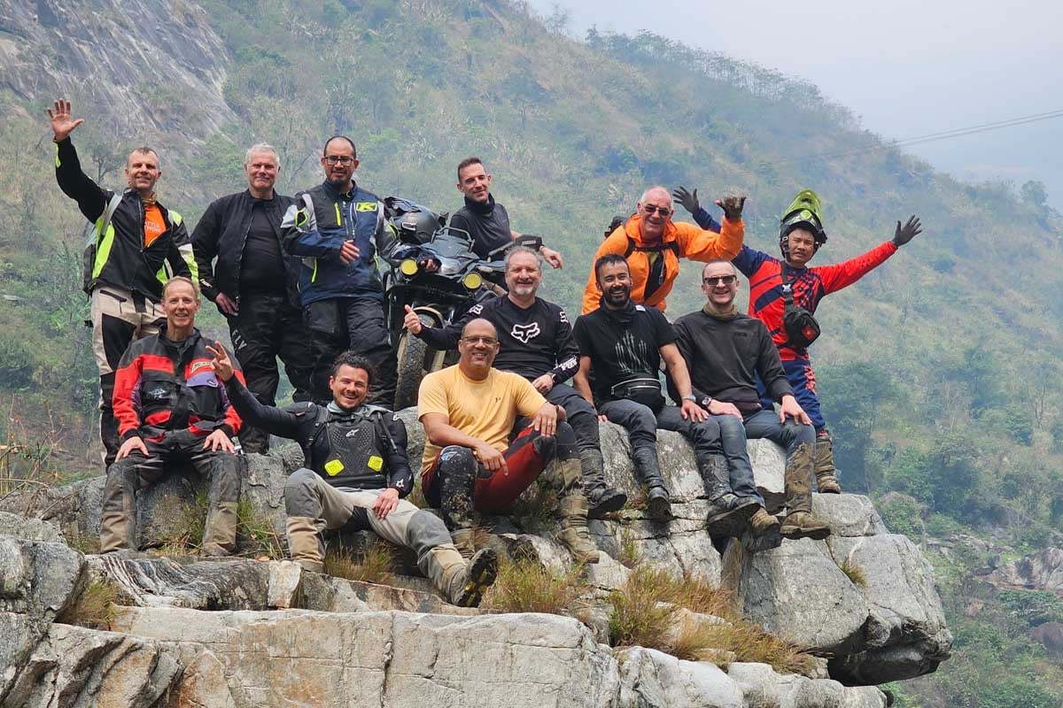 excited-riders-smiling-on-rock-along-river-vietnam