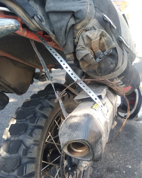 exhaust repair job metal strip to hold up exhaust while motorcycling the bdr