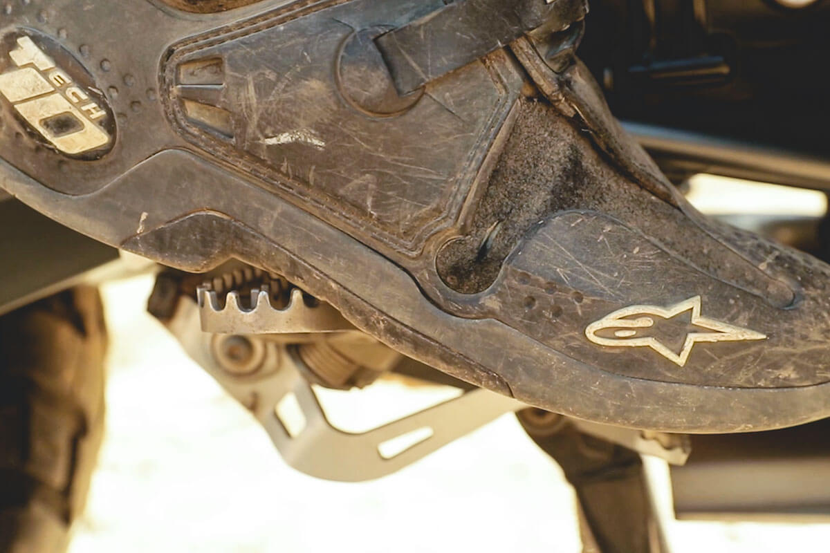 Close up product shot of riders boots with the foot peg motorcycle accessory.