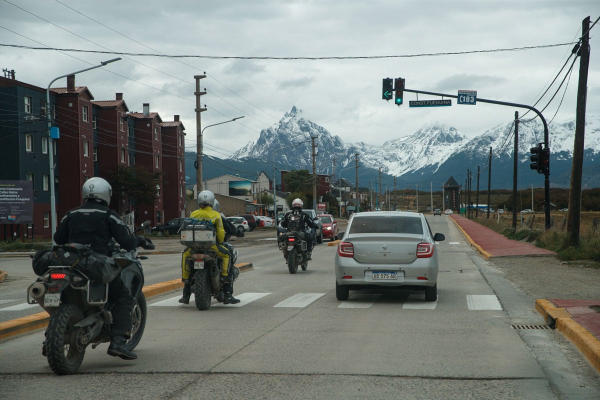 Three Motorcycle riders with full adventure motorcycle gear riding down the street in Ushuaia.