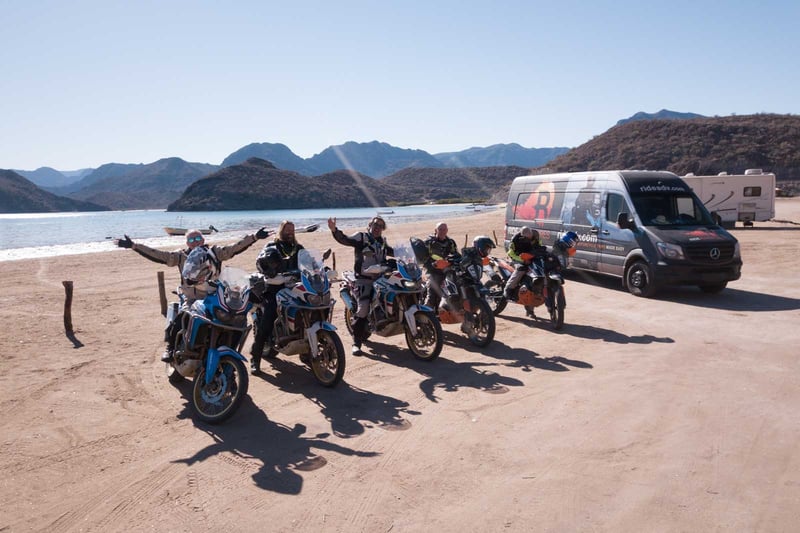 Group of riders parked in a beautiful beach side cove in Baja.