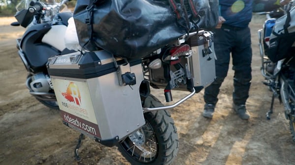 Backside of a bike to show all the small parts that make up the rack system of hard motorcycle cases