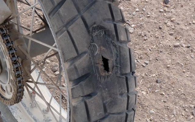 puntured tire on an adventure motorcycle while riding offroad in Africa.