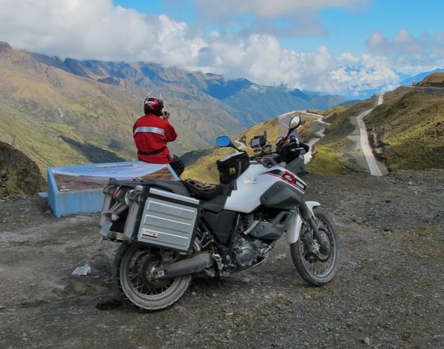 Motorcycle with a tank bag overlooking a mountainous view in Peru.