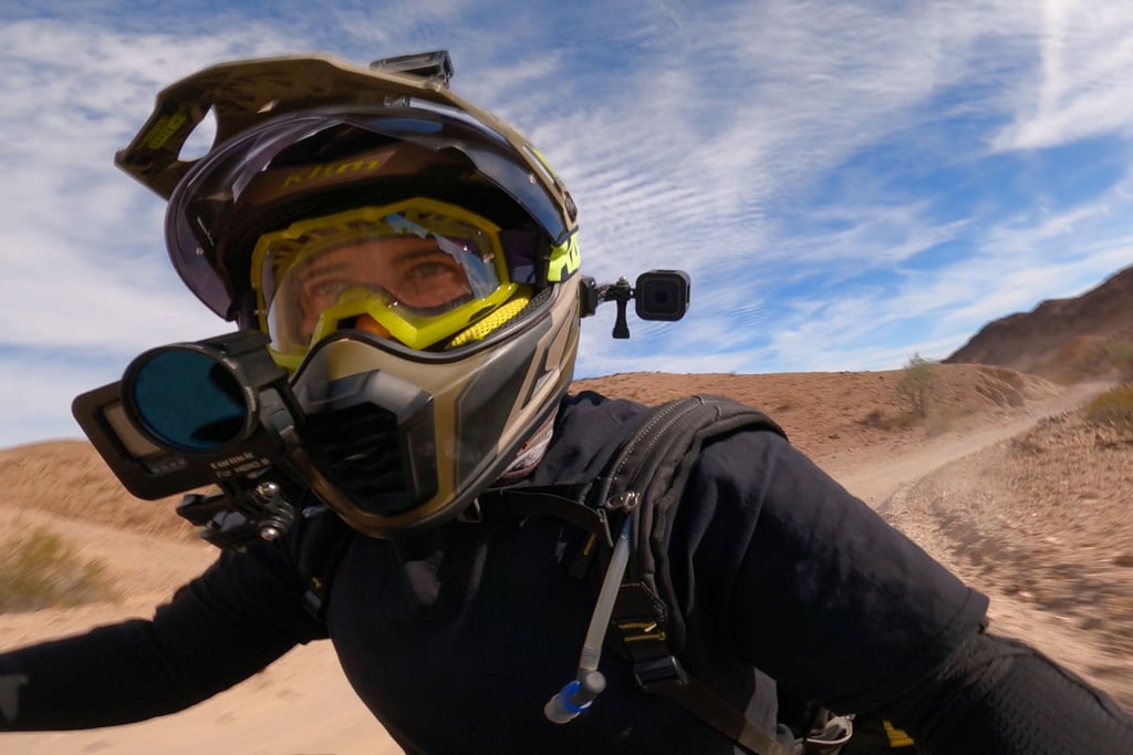 Rider wearing the Klim Viper motorcycle goggles while ripping through the desert.