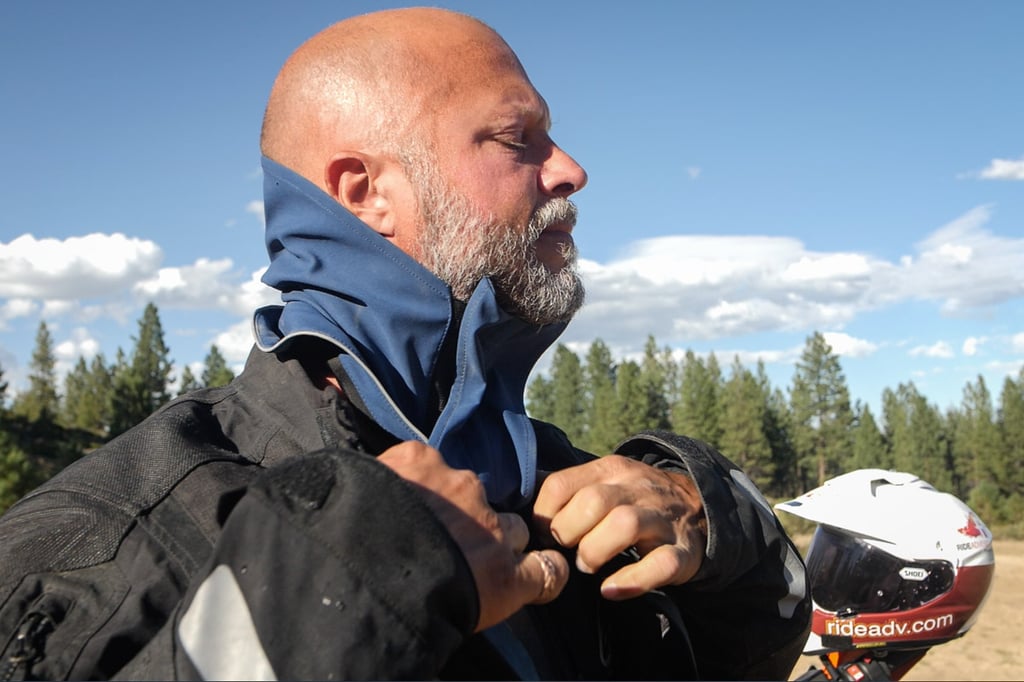 Eric putting on Klim's waterproof storm collar