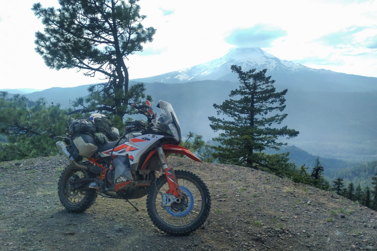 ktm 890 adventure in the forest on a bdr in Oregon with mountain in background