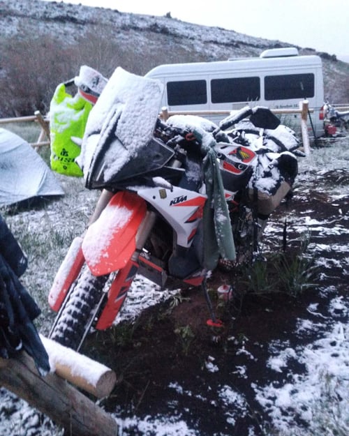 ktm 890 adventure on a dirt trail fully loaded with luggage in a bdr with snow