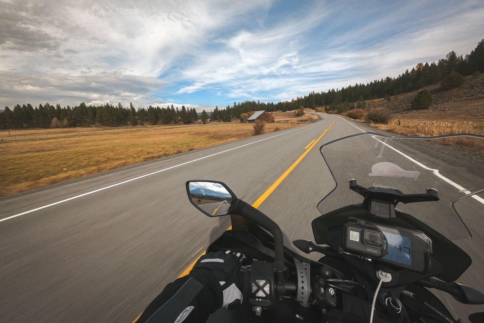 Riding a ;long and winding road with a old barn in the distance. 