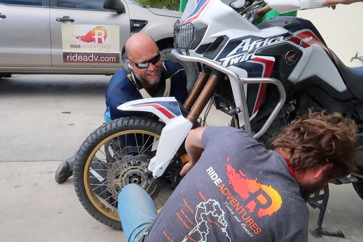 Eric and Eric both on the grown repairing a flat while in Patagonia.