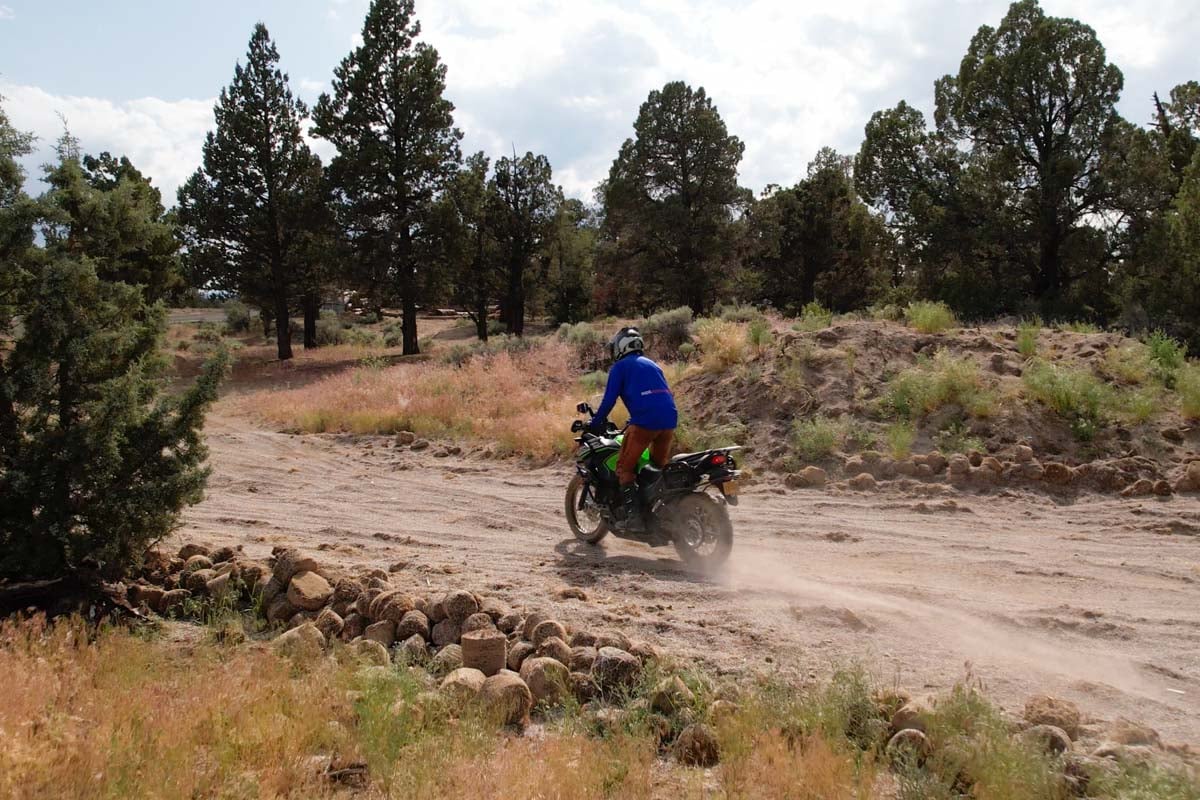 rider ripping up some dust along a trail with the versys-x 300
