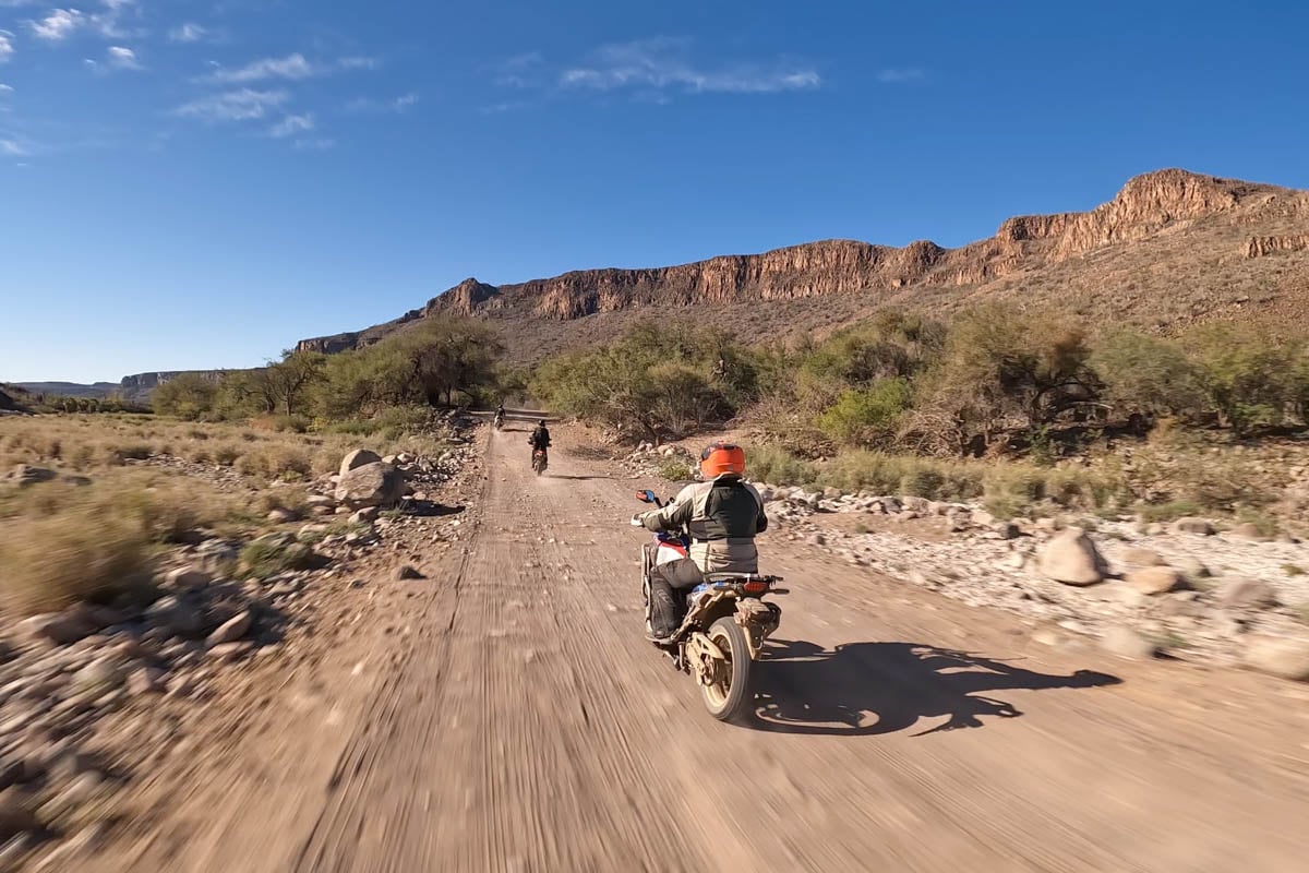 rider-on-dirt-road-with-mountains-in-background
