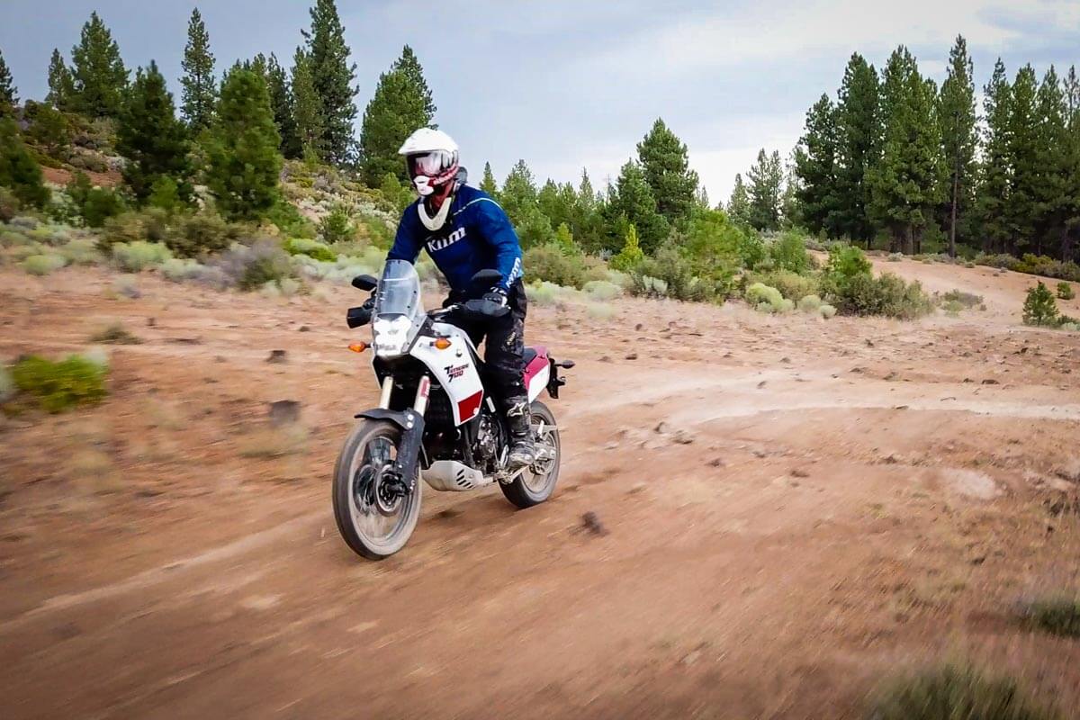 Adventure motorcycle rider Eric Lange going fast down a dirt trail with the Tenere 700.