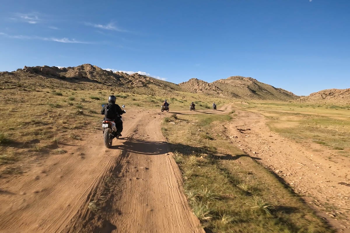 riding behind charles while heading into the mountains in mongolia