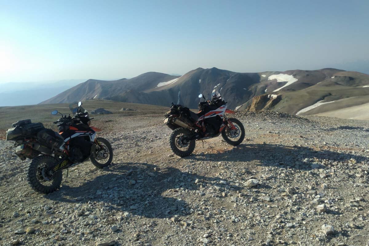 two fully luggage loaded ktm 890 adventures on a hill top overlooking mountains on the Norcal BDR