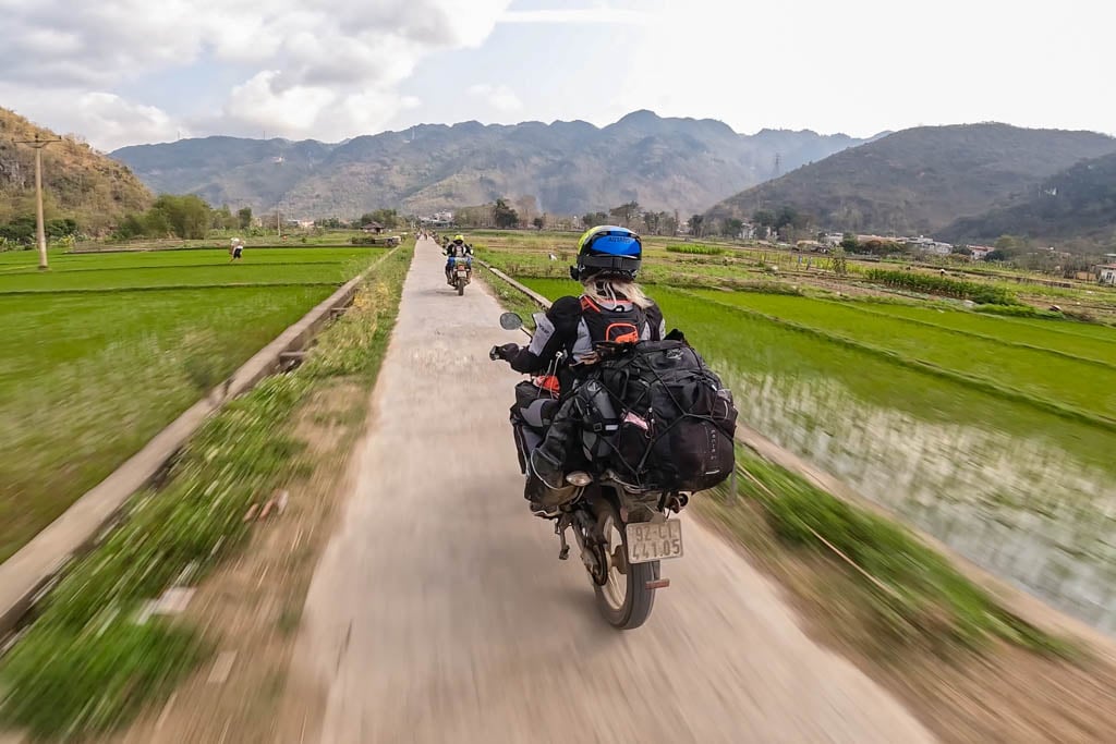 motorcycle-riders-through-a-rice-field-in-northern-vietnam