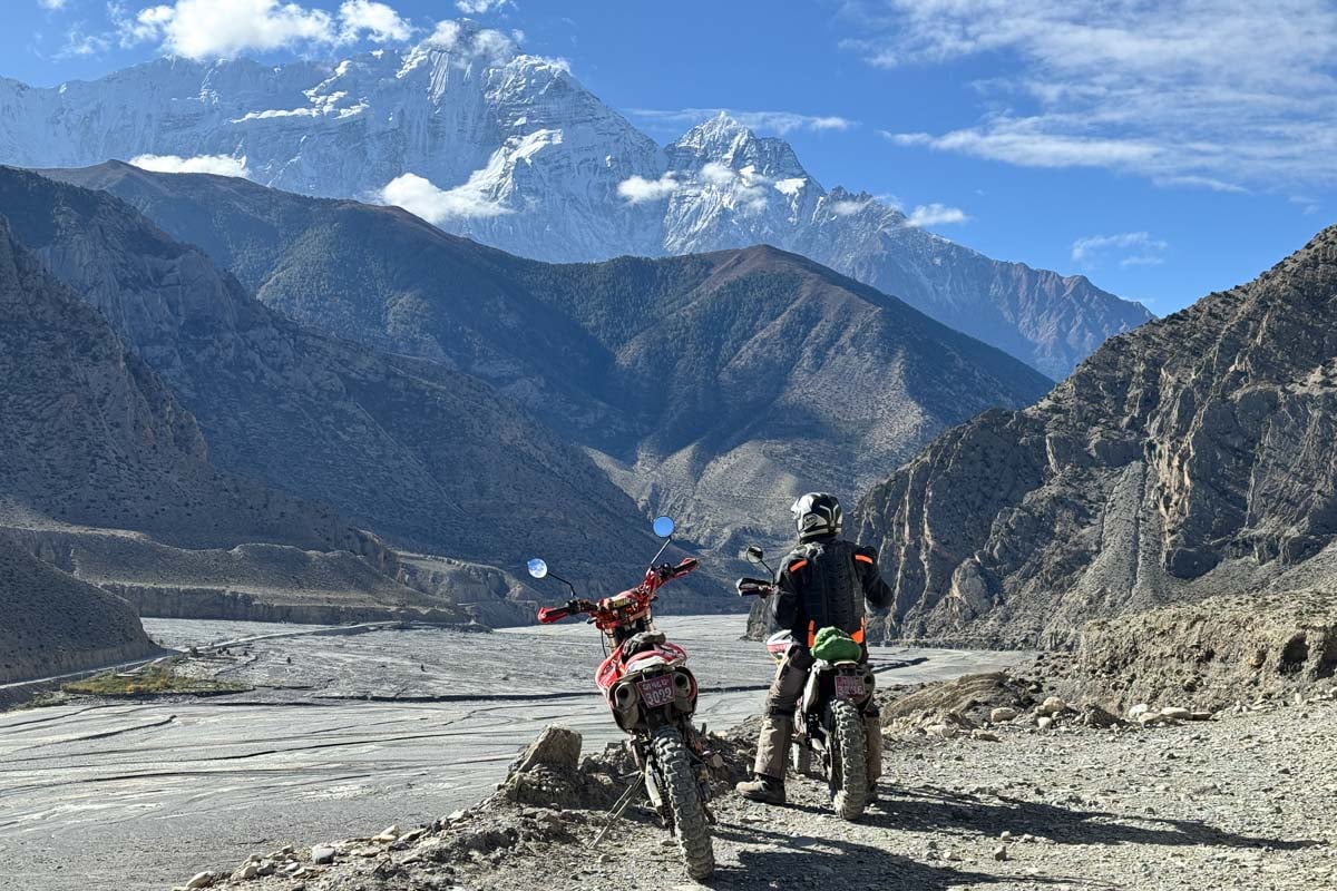 riders-admiring-the-view-of-dried-up-riverbed-with-himalaya-mountains-nepal